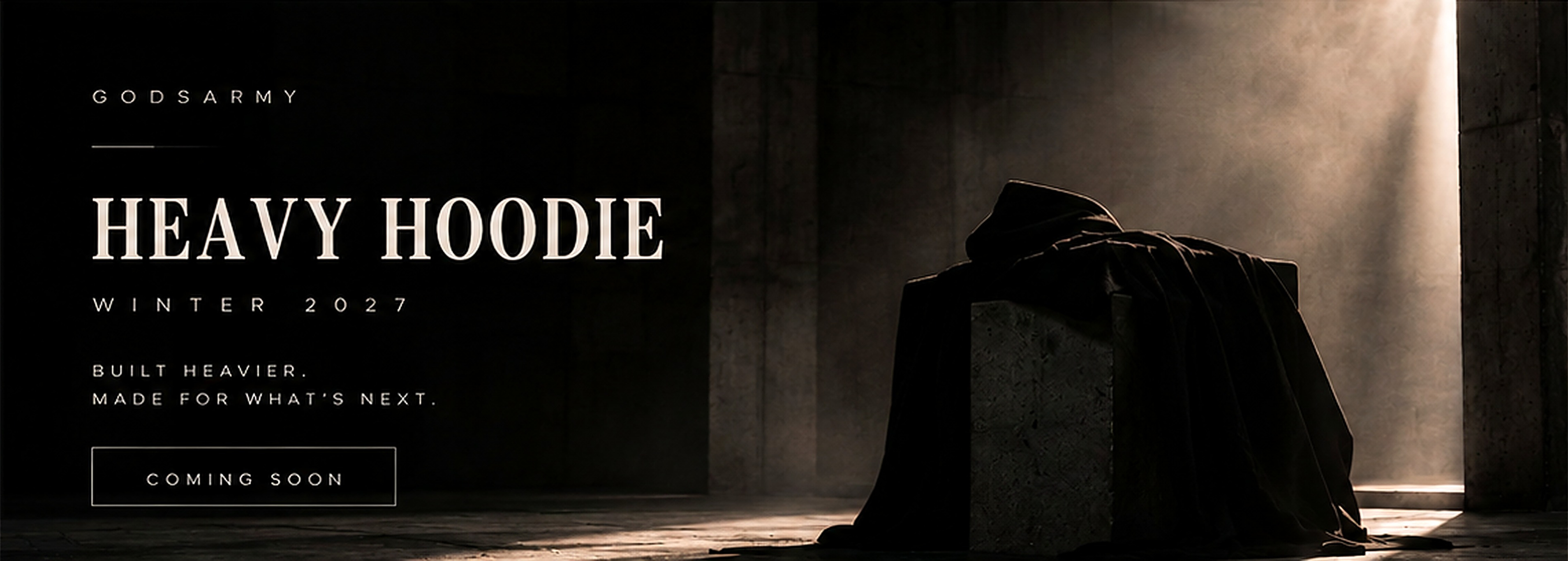 Heavy Hoodie Winter 2027 teaser: black hoodie draped over concrete in a shaft of light